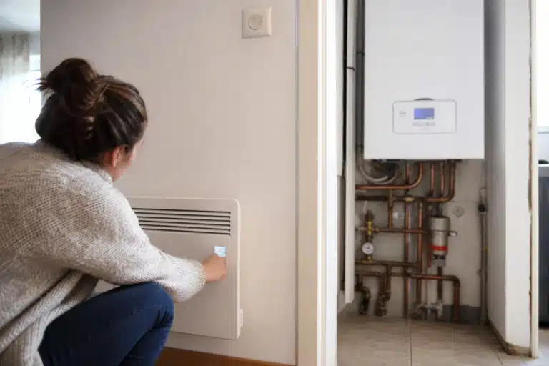 Personne ajustant thermostat près d'une chaudière