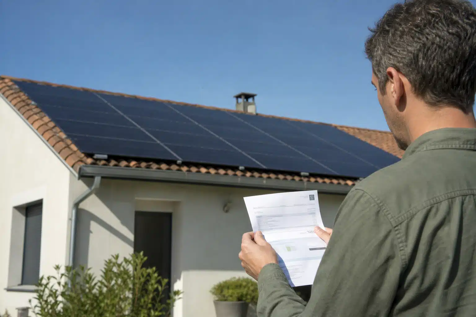 Technicien vérifiant des documents devant panneaux solaires